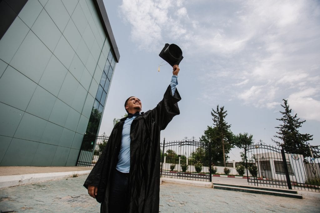 graduation nominated man graduation graduate graduation gown graduation cap young man wide angle sky