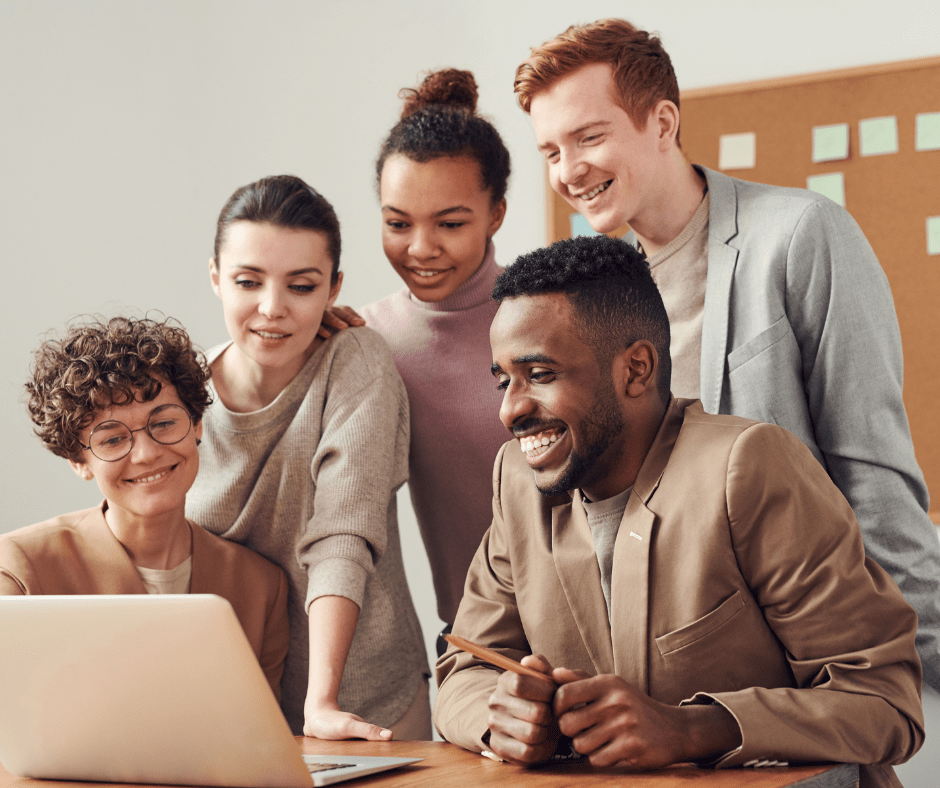 Team gathering around a laptop