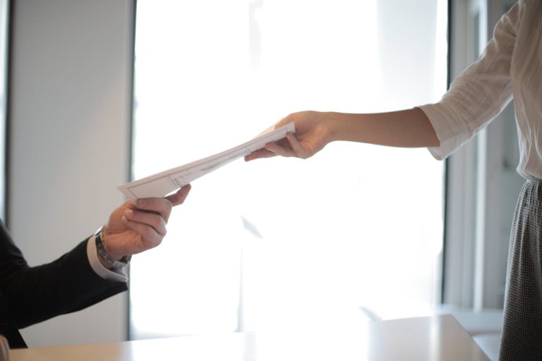 A person handing over their resume